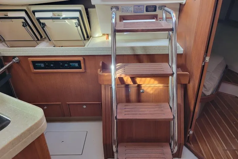 Slide: The Image of Interior of 2008 Island Packet 370 yacht with wooden steps and compact kitchen area. - 36