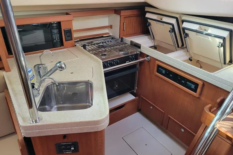 Slide: The Image of 2008 Island Packet 370 yacht kitchen with sink, stove, and storage compartments. - 39