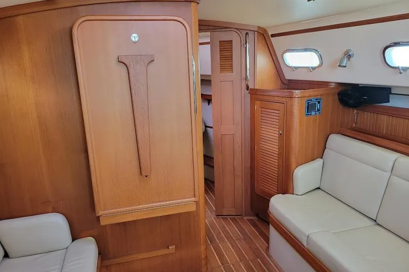 Slide: The Image of Interior of 2008 Island Packet 370 sailboat with wood paneling and beige seating. - 46