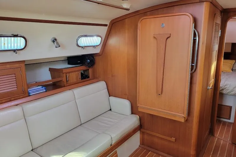 Slide: The Image of Interior of 2008 Island Packet 370 sailboat with wooden cabinetry and beige seating. - 47