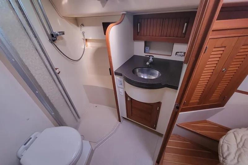 Slide: The Image of 2008 Island Packet 370 yacht bathroom with shower, sink, and wooden cabinetry. - 68