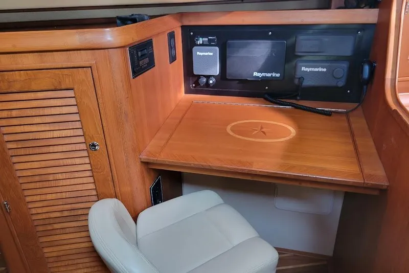 Slide: The Image of Navigation station of 2008 Island Packet 370 yacht with Raymarine equipment and wooden finish. - 69