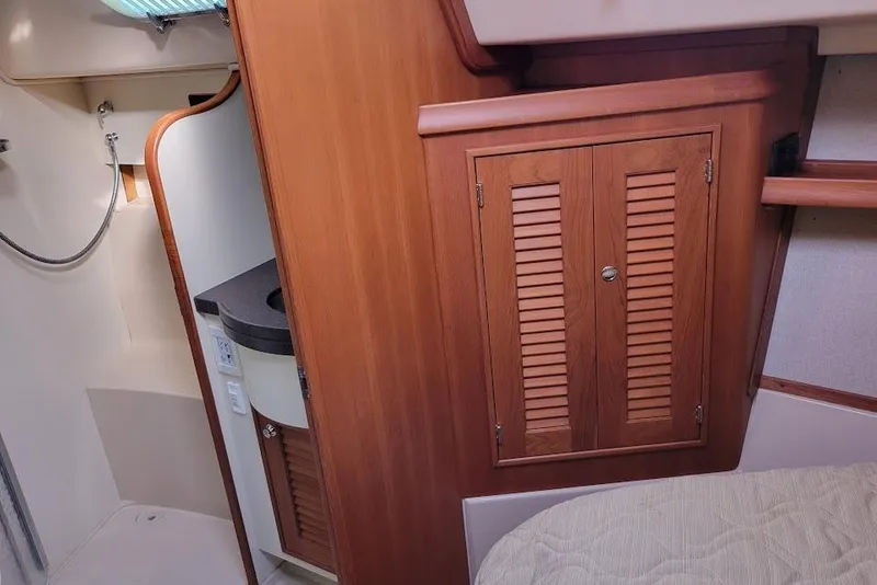 Slide: The Image of 2008 Island Packet 370 interior with wooden cabinetry and compact bathroom area. - 75