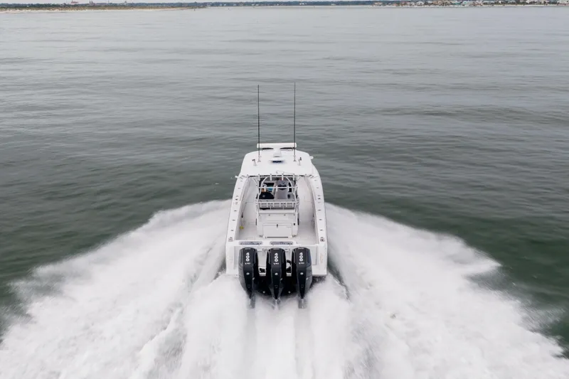 Slide: The Image of 2016 Contender 39 ST boat speeding on open water, rear view. - 11