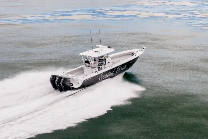 Slide: The Image of 2016 Contender 39 ST boat speeding on open water, showcasing powerful engines. - 15