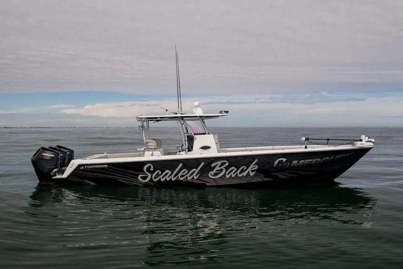 Slide: The Image of 2016 Contender 39 ST boat on calm water, featuring "Scaled Back" graphics. - 2