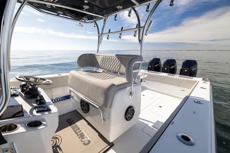 Slide: The Image of 2016 Contender 39 ST boat interior with helm, seating, and multiple outboard motors on calm water. - 32