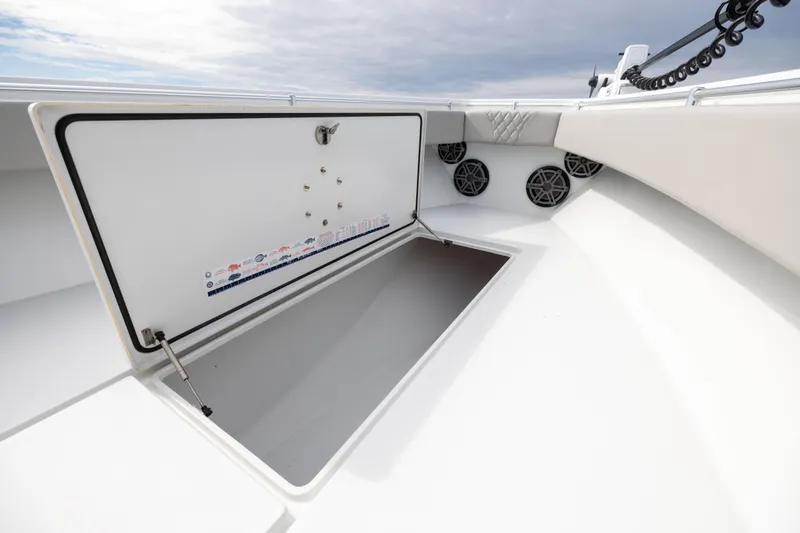 Slide: The Image of Open storage compartment on 2016 Contender 39 ST boat, featuring speakers and cushioned seating. - 56