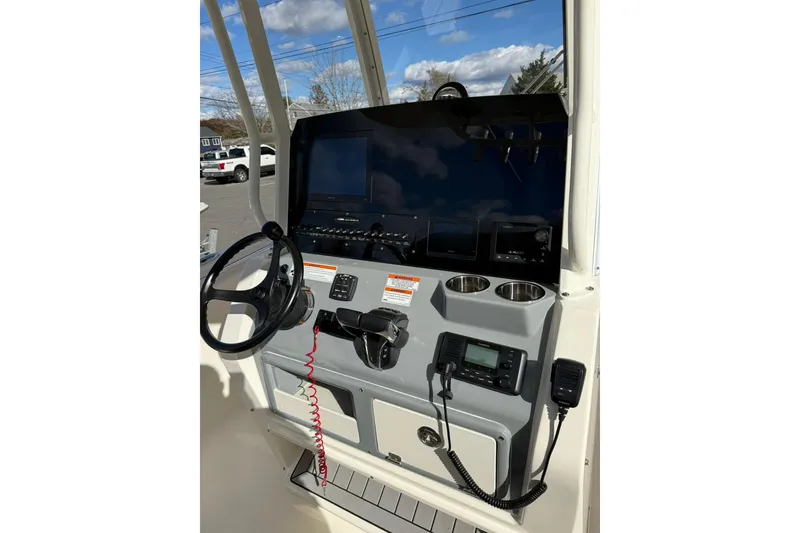 Slide: The Image of 2022 Cobia 262 Center Console boat dashboard with steering wheel and navigation controls. - 10