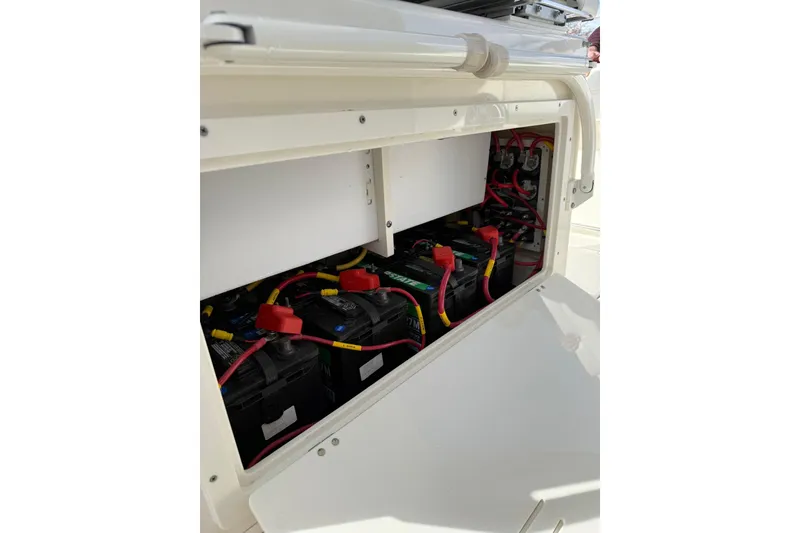 Slide: The Image of 2022 Cobia 262 Center Console boat battery compartment with wiring and connections. - 12