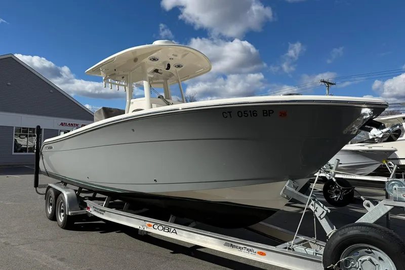 Slide: The Image of 2022 Cobia 262 Center Console boat on trailer under blue sky. - 2