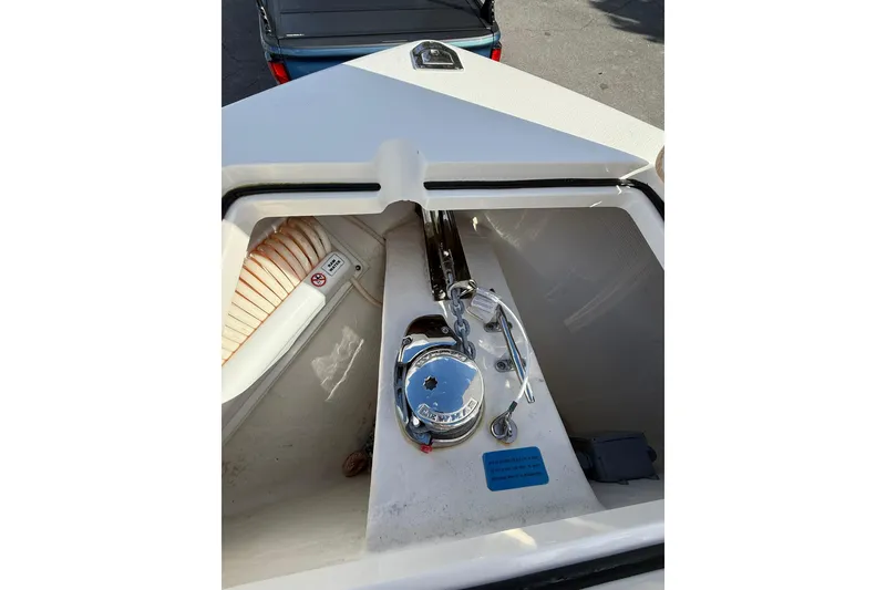 Slide: The Image of 2022 Cobia 262 Center Console boat anchor compartment with chain and winch. - 22