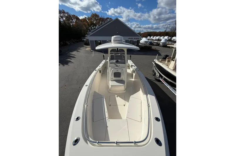 Slide: The Image of 2022 Cobia 262 Center Console boat with Garmin equipment, parked outdoors under a blue sky. - 23