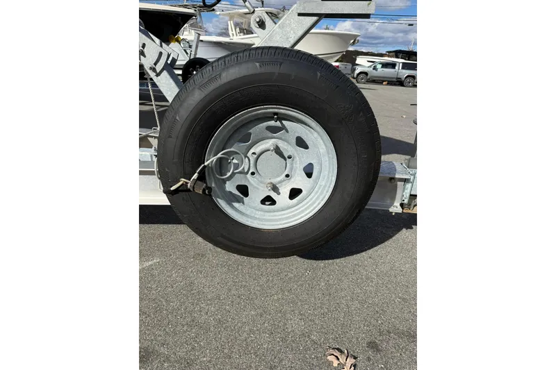 Slide: The Image of Trailer wheel for 2022 Cobia 262 Center Console boat on asphalt. - 3