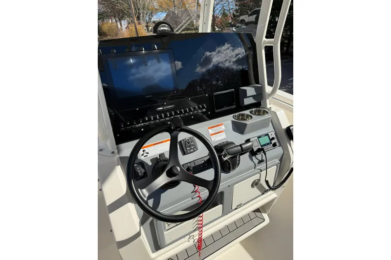 Slide: The Image of 2022 Cobia 262 Center Console boat dashboard with steering wheel and electronic controls. - 9