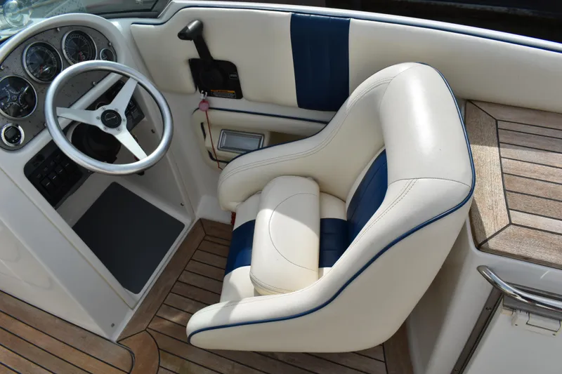 Slide: The Image of 2003 Chris-Craft Launch 25 boat interior with steering wheel and cushioned seat. - 22