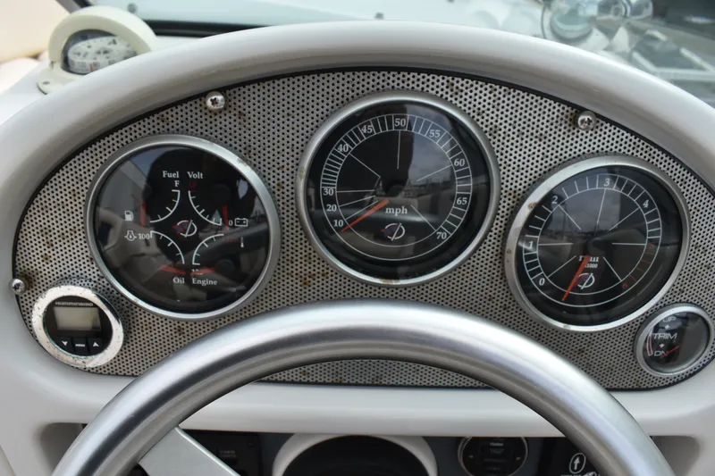 Slide: The Image of Dashboard of a 2003 Chris-Craft Launch 25 boat with gauges and steering wheel. - 25