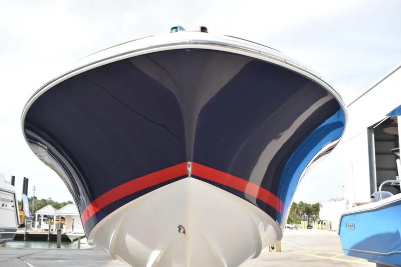 Slide: The Image of 2003 Chris-Craft Launch 25 boat, navy hull with red stripe, docked at marina. - 3