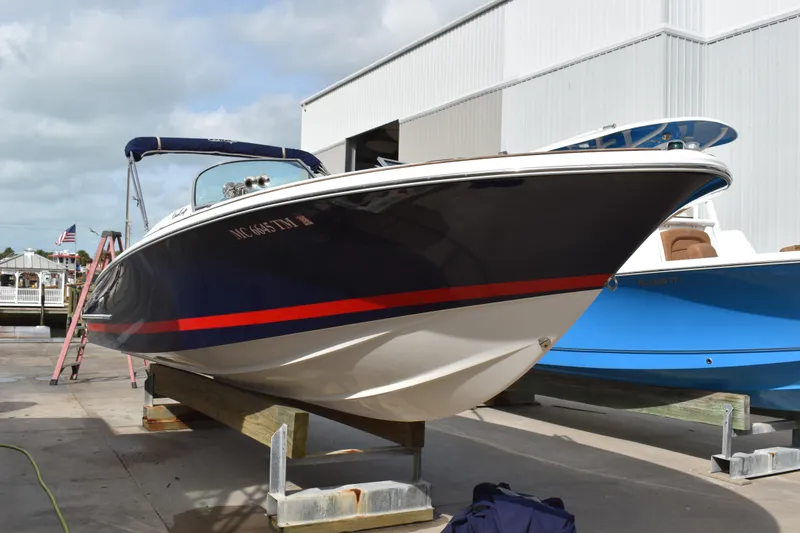 Slide: The Image of 2003 Chris-Craft Launch 25 boat on display at a marina, featuring a sleek design. - 4