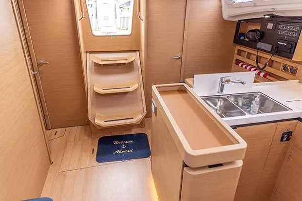 Slide: The Image of Interior of 2020 Jeanneau Sun Odyssey 410 yacht, featuring modern kitchen and wooden cabinetry. - 9