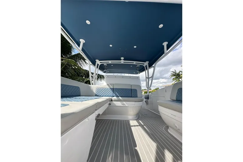 Slide: The Image of Interior view of 2021 Intrepid 409 Valor boat with blue seating and canopy. - 18