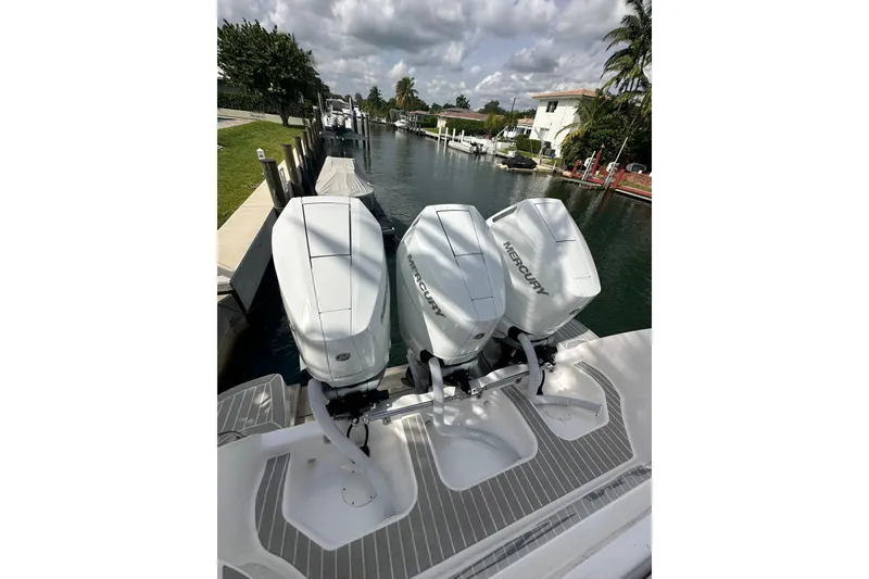 Slide: The Image of 2021 Intrepid 409 Valor with triple Mercury outboard engines docked by a canal. - 22