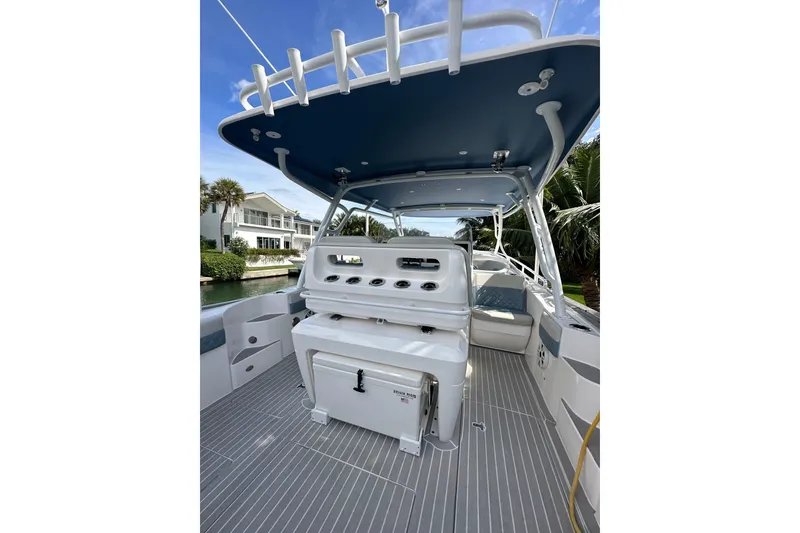 Slide: The Image of 2021 Intrepid 409 Valor boat interior with seating and storage, docked near waterfront homes. - 24