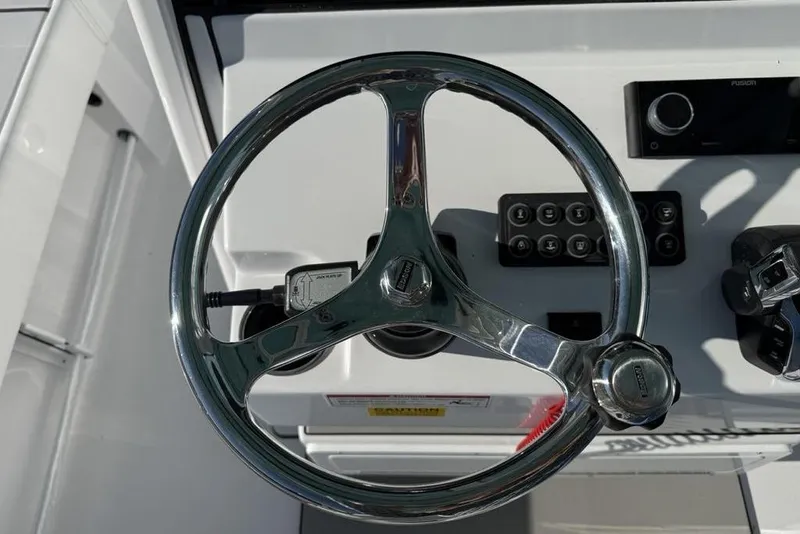 Slide: The Image of Steering wheel of 2026 Sportsman Masters 247OE Bay Boat, featuring control panel and throttle. - 17