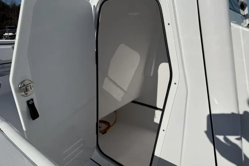 Slide: The Image of 2026 Sportsman Masters 247OE Bay Boat interior storage compartment with open door. - 26