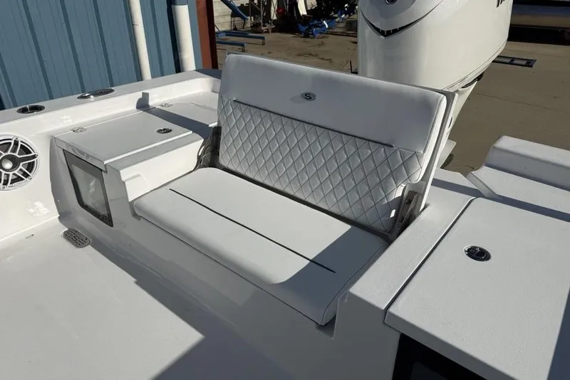 Slide: The Image of 2026 Sportsman Masters 247OE Bay Boat with white cushioned seating and storage compartments. - 36