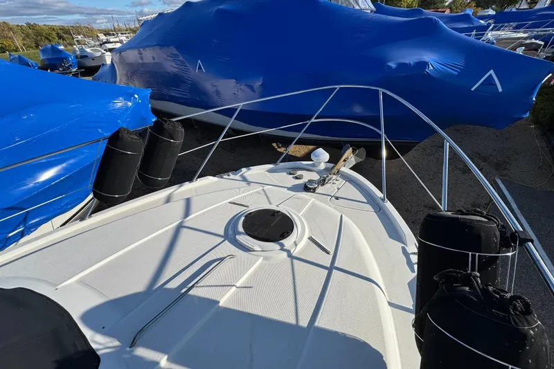 Slide: The Image of 2005 Meridian 368 Motoryacht bow view with blue-covered boats in background. - 12