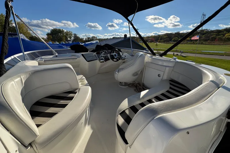 Slide: The Image of 2005 Meridian 368 Motoryacht interior with white seating and steering console under a sunny sky. - 13