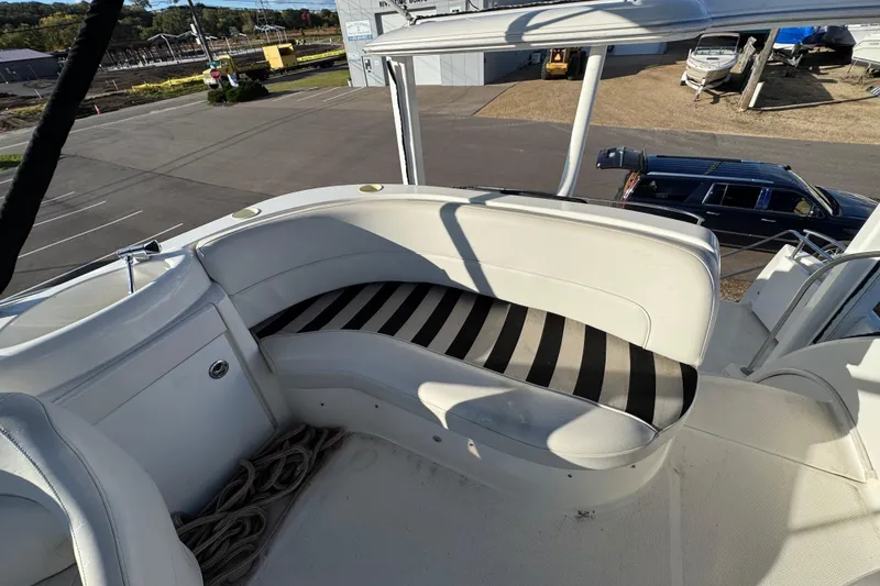 Slide: The Image of 2005 Meridian 368 Motoryacht with striped seating on upper deck, parked near vehicles. - 16