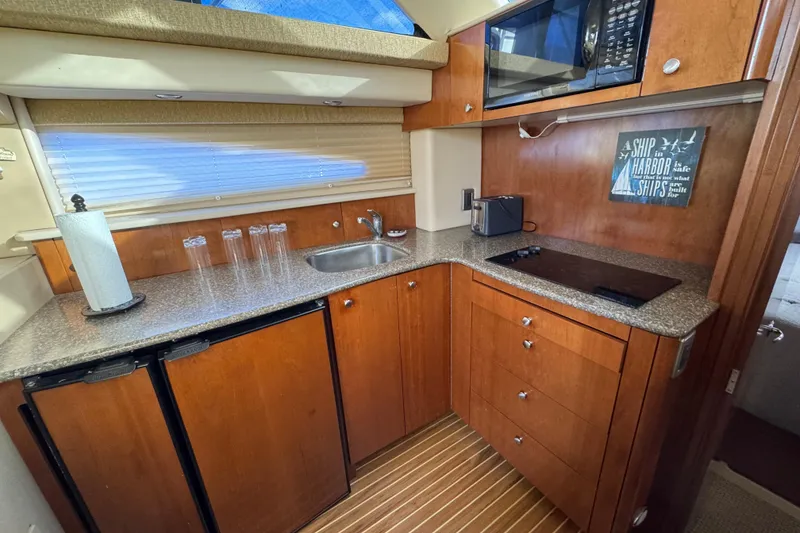 Slide: The Image of 2005 Meridian 368 Motoryacht kitchen with wood cabinetry, countertop, sink, and appliances. - 39
