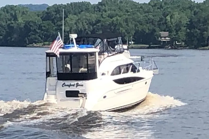 Slide: The Image of 2005 Meridian 368 Motoryacht cruising on a river with lush green trees. - 4