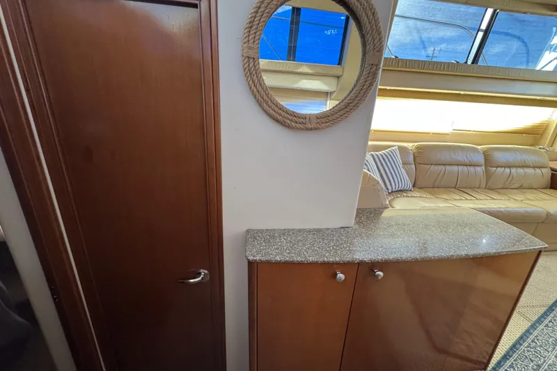 Slide: The Image of 2005 Meridian 368 Motoryacht interior with wooden cabinetry, rope mirror, and leather seating. - 47