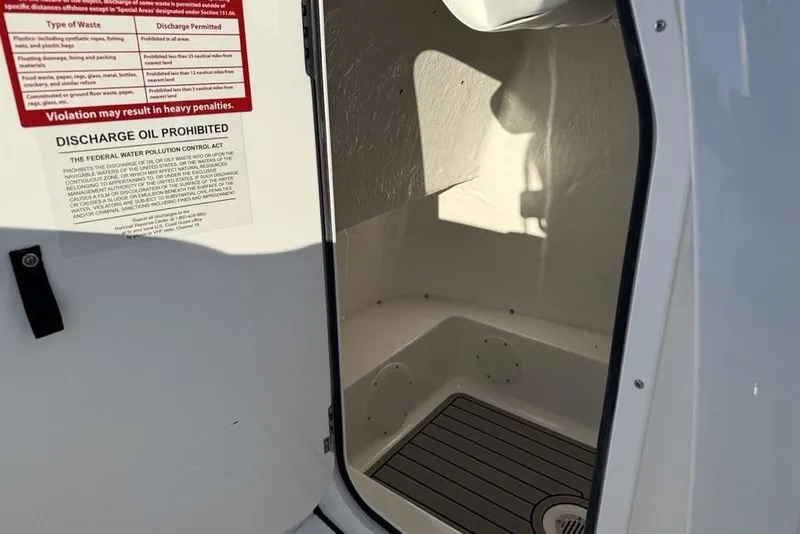 Slide: The Image of Interior of 2026 Tidewater 210 LXF boat with discharge warning sign. - 15