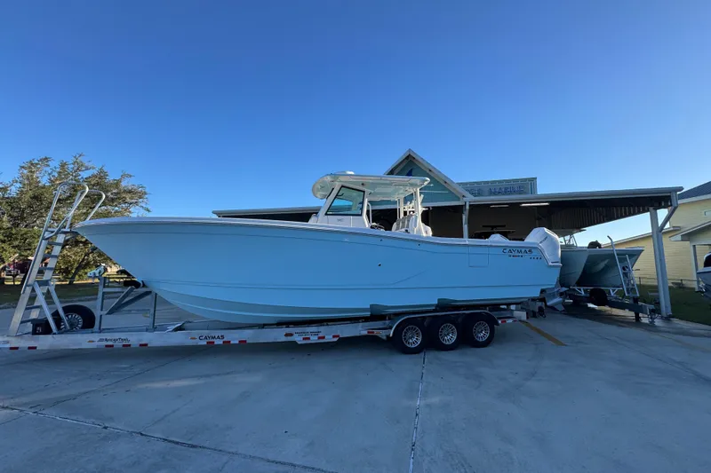 The Image of 2026 Caymas 34 CT boat on trailer, parked outside a marine facility. - 1
