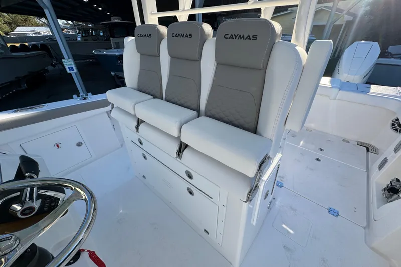 Slide: The Image of 2026 Caymas 34 CT boat interior with three cushioned seats and steering wheel. - 21
