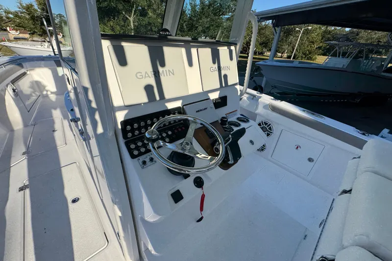Slide: The Image of 2026 Caymas 34 CT boat helm with Garmin displays and Mercury controls. - 23