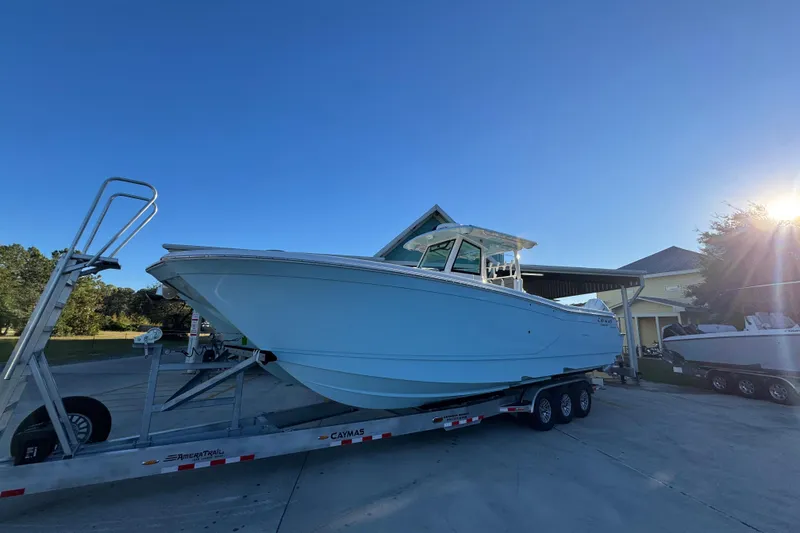 Slide: The Image of 2026 Caymas 34 CT boat on trailer under clear blue sky. - 3