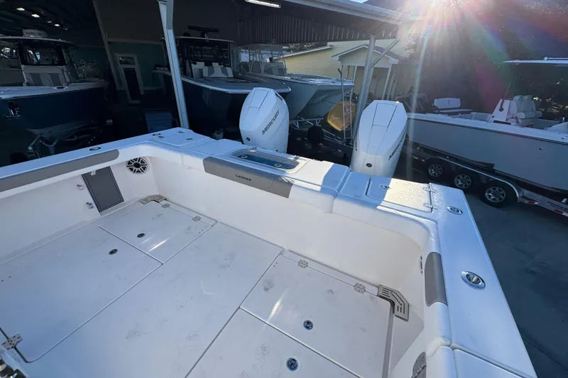 Slide: The Image of 2026 Caymas 34 CT boat with dual Mercury engines in a sunlit marina. - 32