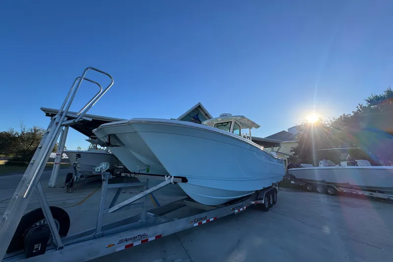 Slide: The Image of 2026 Caymas 34 CT boat on trailer under clear blue sky with sunflare. - 4