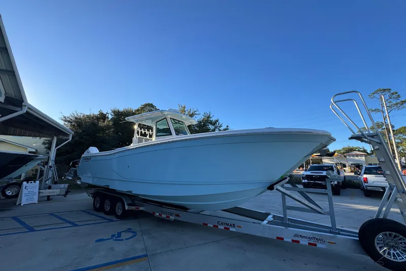 Slide: The Image of 2026 Caymas 34 CT boat on trailer, displayed outdoors under clear blue sky. - 6