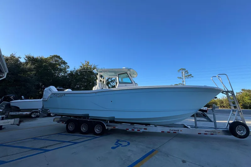 Slide: The Image of 2026 Caymas 34 CT boat on trailer, parked outdoors under clear blue sky. - 7