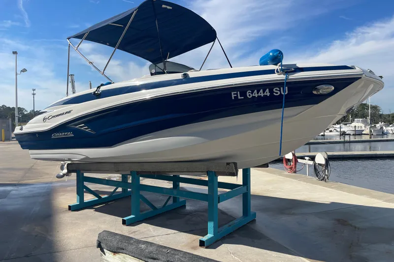 The Image of 2019 Crownline Eclipse E205 XS boat on a dock, blue and white design, marina background. - 0