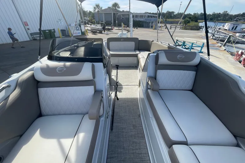 Slide: The Image of 2019 Crownline Eclipse E205 XS boat interior with plush seating at a marina. - 6