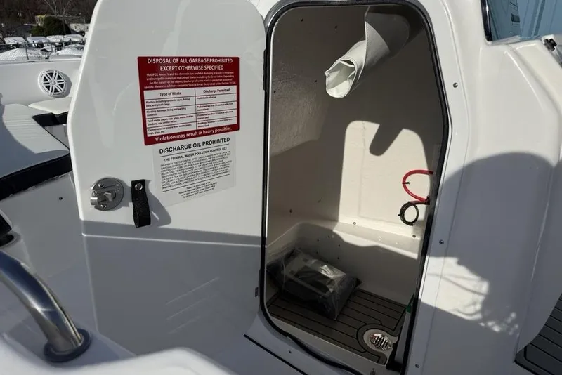 Slide: The Image of Open storage compartment on 2026 Tidewater 198 CC Adventure boat with safety notices. - 19