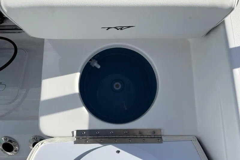 Slide: The Image of 2026 Tidewater 198 CC Adventure boat livewell with white seating and blue interior. - 30