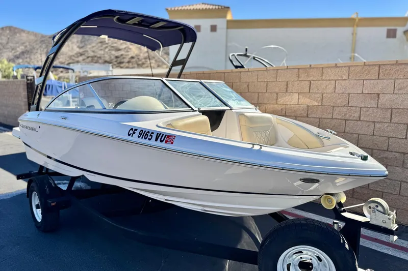 Slide: The Image of 2020 Regal 1900 ES Bowrider boat on trailer, parked outdoors. - 1